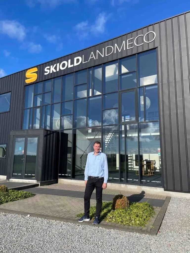 Professional standing in front of the LANDMECO headquarters building in Ølgod, Denmark, poultry equipment manufacturer.