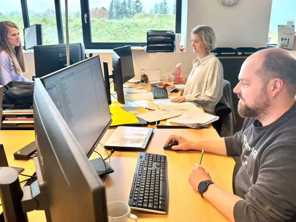 LANDMECO sales support team working at desks in the Ølgod office, managing poultry equipment orders and inquiries.
