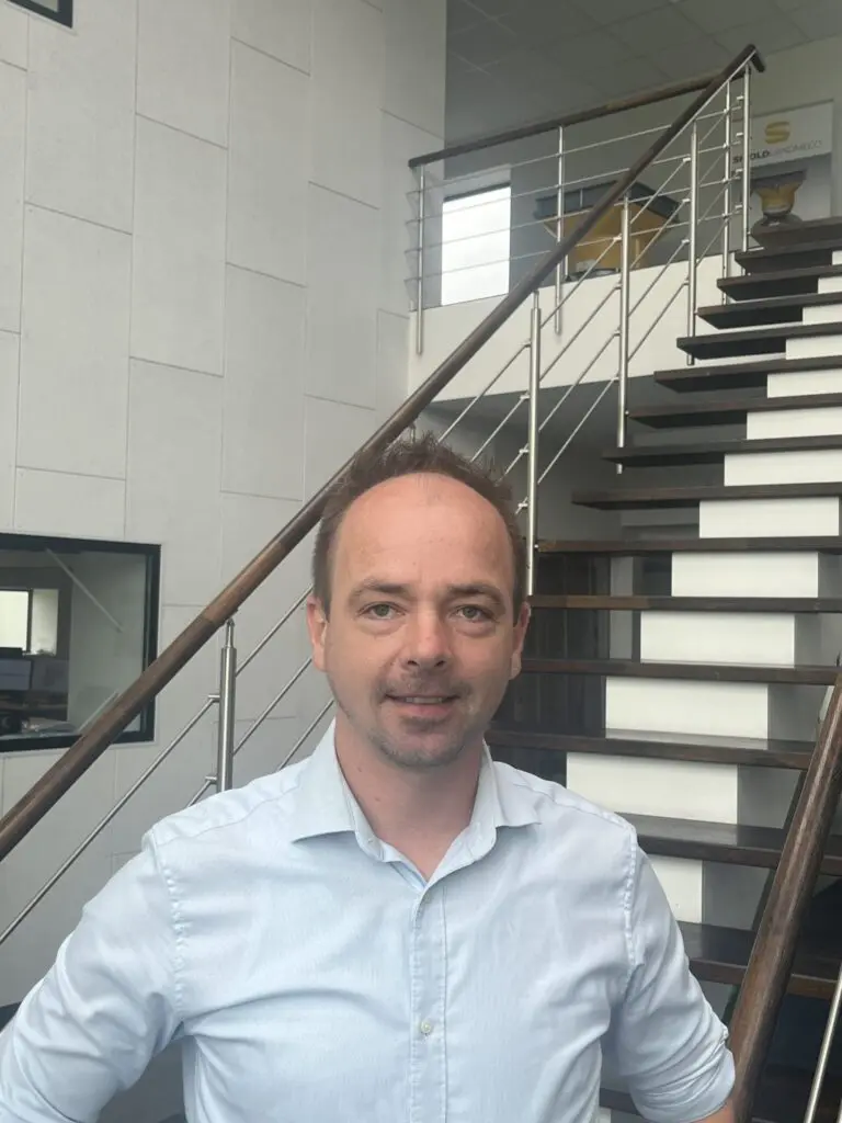 Rune Scaled from LANDMECO standing in a modern office, representing Scandinavian poultry equipment expertise.