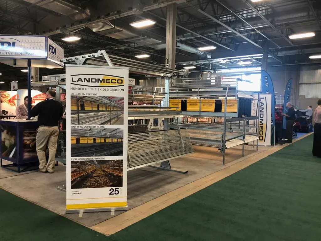 LANDMECO trade show booth showcasing Combo aviary systems and rearing equipment for professional poultry producers.