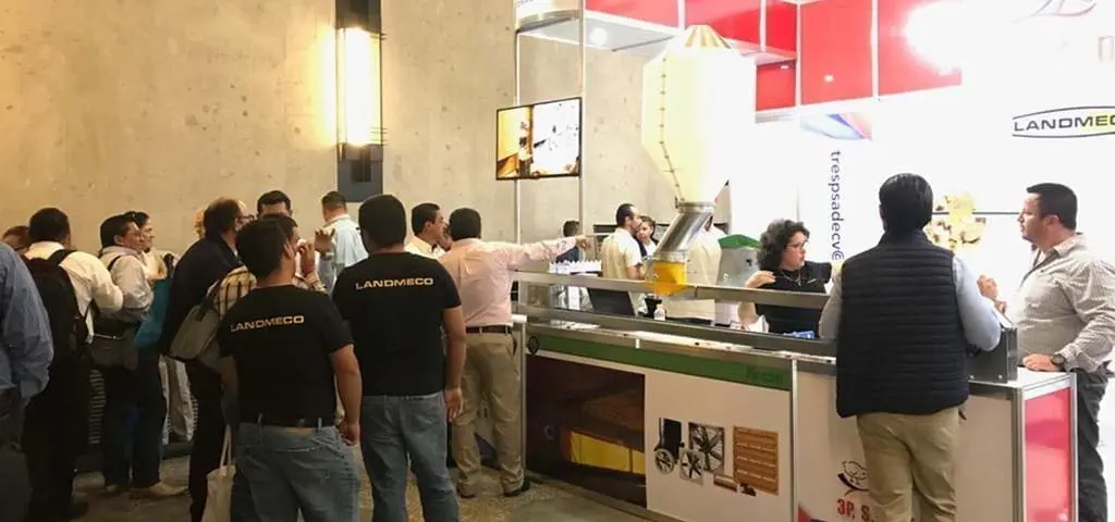 LANDMECO trade show booth featuring poultry farming equipment and systems with industry professionals.