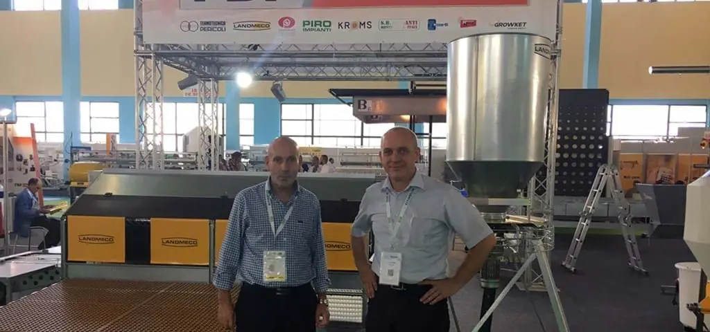 LANDMECO specialists showcasing poultry feeding systems and aviary equipment at a professional industry trade fair.