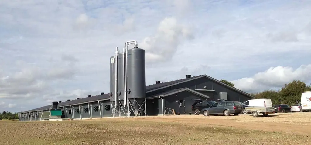 Modern poultry house with large feed silos and automated systems from LANDMECO, Denmark.