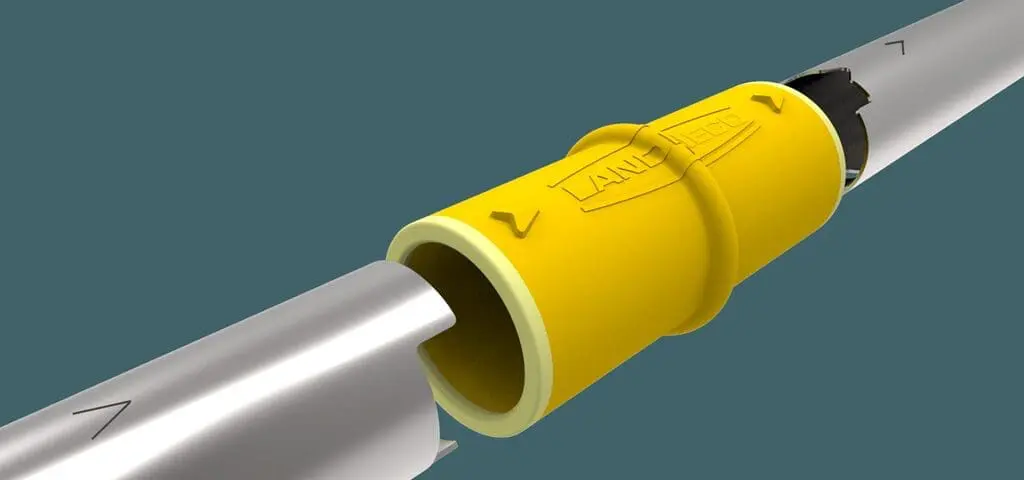 Close-up of a yellow Landmeco Safe Connector joining two metal pipes in a professional poultry production system.