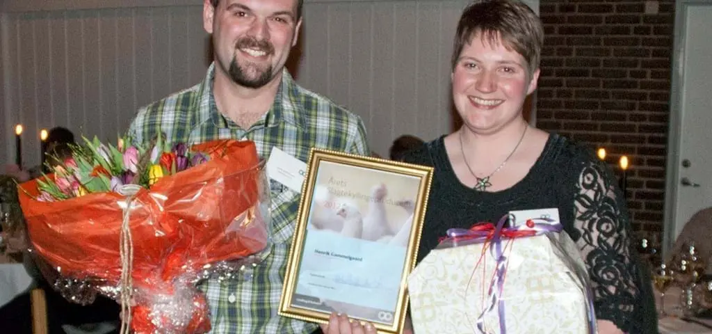 Award winners holding flowers and the Landmeco Årets Slagtekyllingeproducent certificate for broiler production.