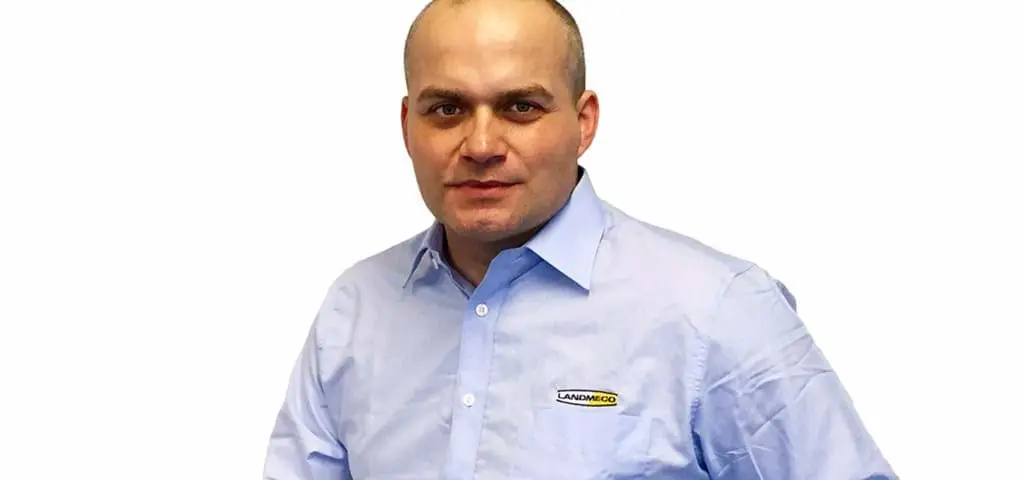 Tomasz, a professional from LANDMECO, wearing a branded light blue shirt against a white background.