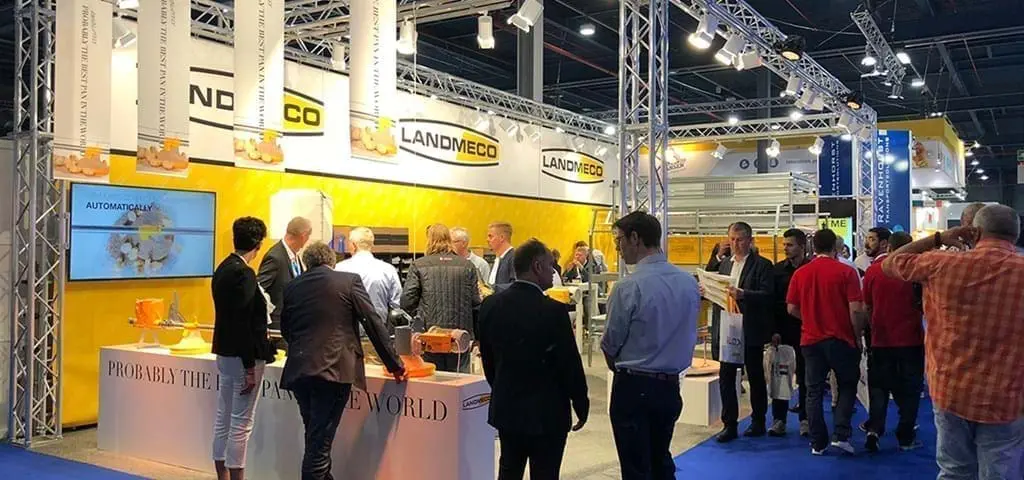 LANDMECO booth at VIV exhibition showcasing automated pan feeding systems and poultry house equipment to visitors.