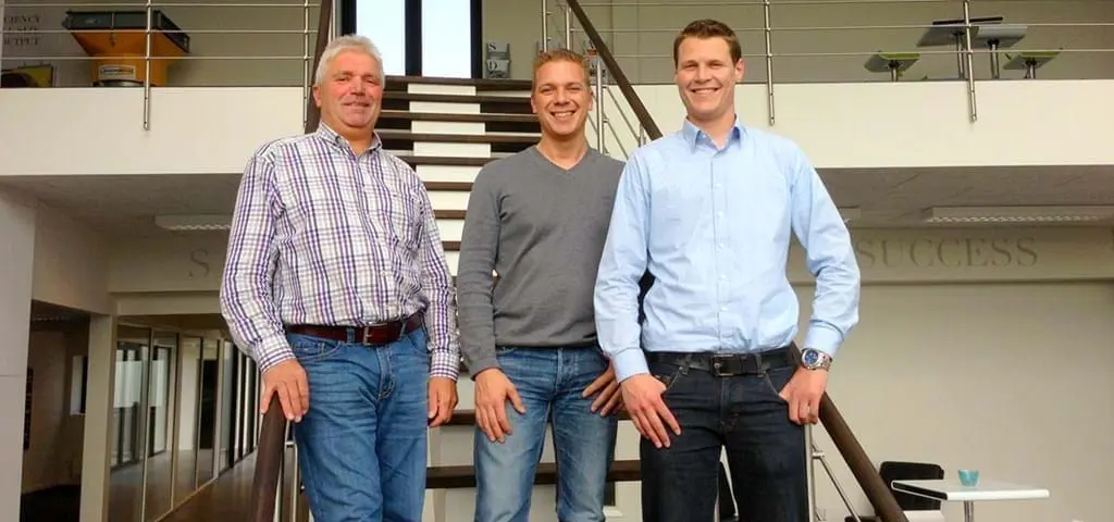 Three LANDMECO team members standing in a modern office, representing professional poultry equipment expertise.