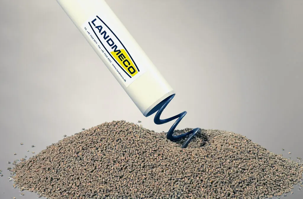 LANDMECO blue flex auger spiral transporting poultry feed pellets from a white PVC delivery tube.