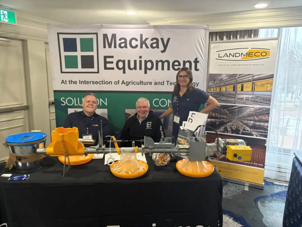 Mackay Equipment booth with LANDMECO poultry feeding systems and staff at a Canadian trade show in Saskatoon.