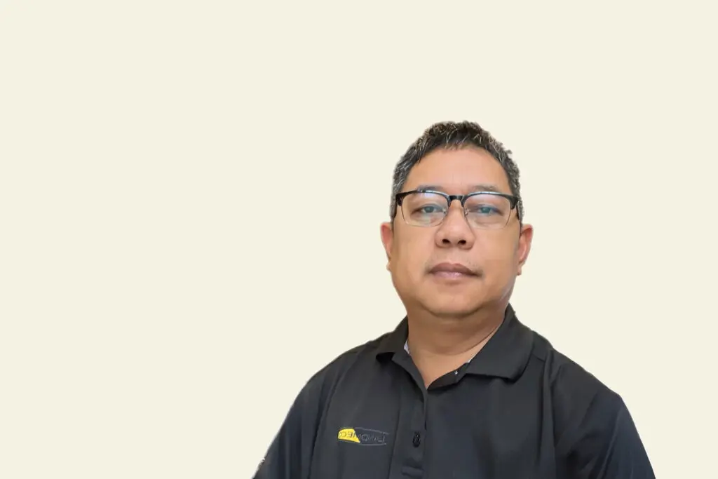 Roland Grabador Jr., LANDMECO Area Sales Manager for the Philippines, in a black branded polo shirt with glasses.
