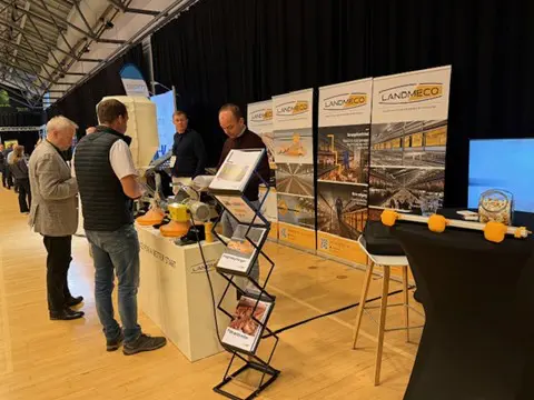 LANDMECOs stand på Fjerkrækongressen med besøgende og medarbejdere, der drøfter moderne fjerkræsystemer.