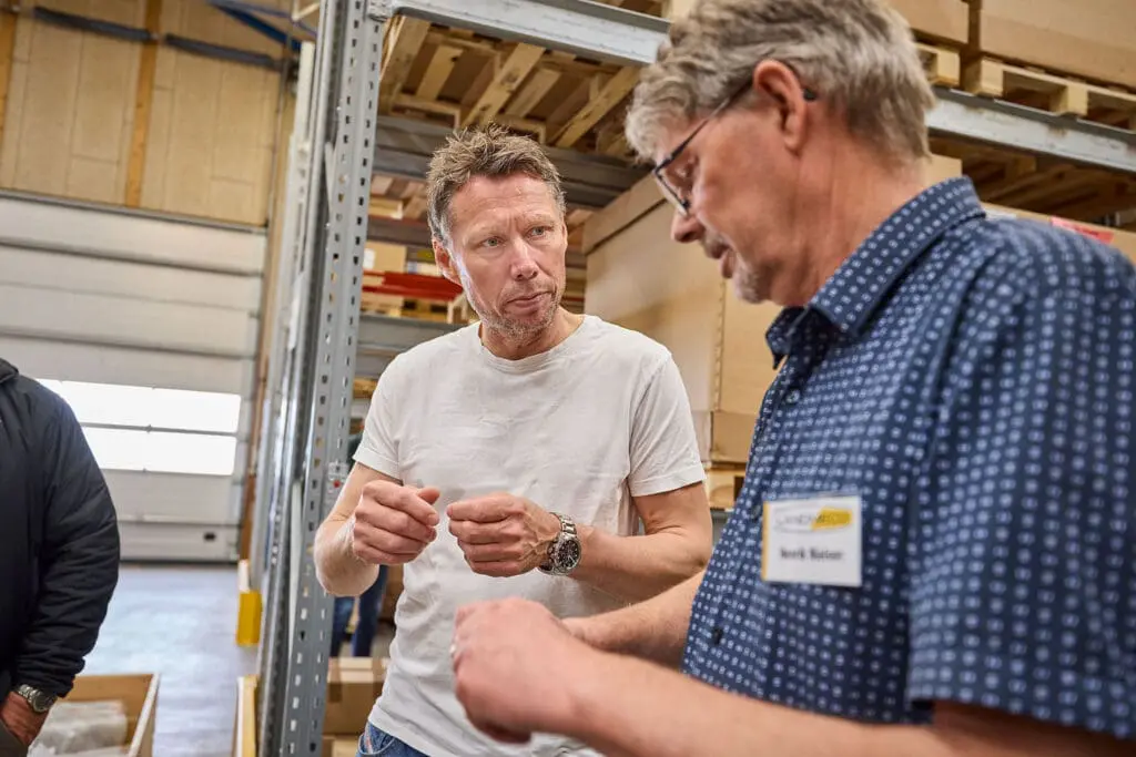 Professionals discussing technical poultry equipment solutions at a LANDMECO seminar in Denmark.