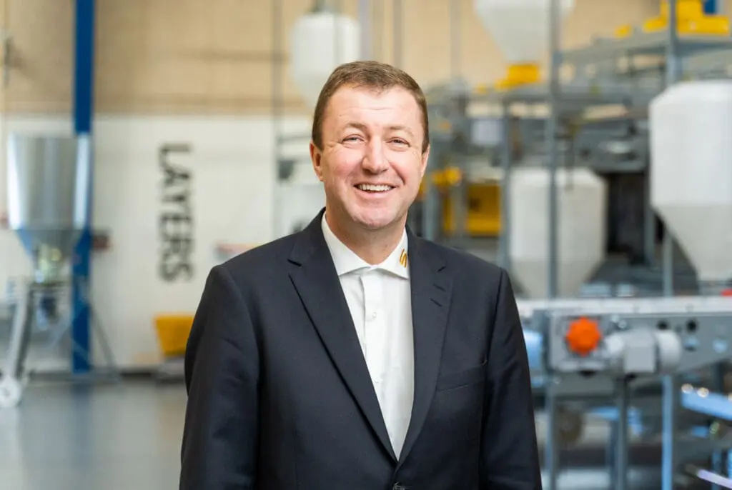 Portrait of Anders Kristian Andersen, CEO of LANDMECO, in an industrial setting with 'LAYERS' signage in the background.