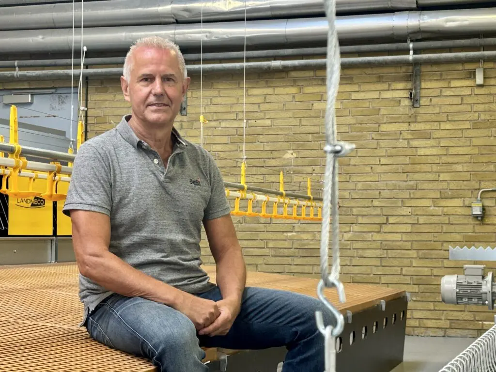 Ryan Zinglersen, International Dealer Manager at LANDMECO, sitting in a facility with poultry equipment.