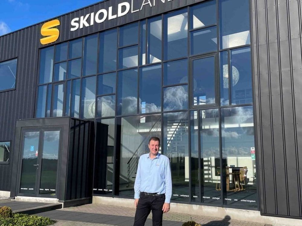 Professional standing in front of the LANDMECO headquarters building in Ølgod, Denmark, poultry equipment manufacturer.