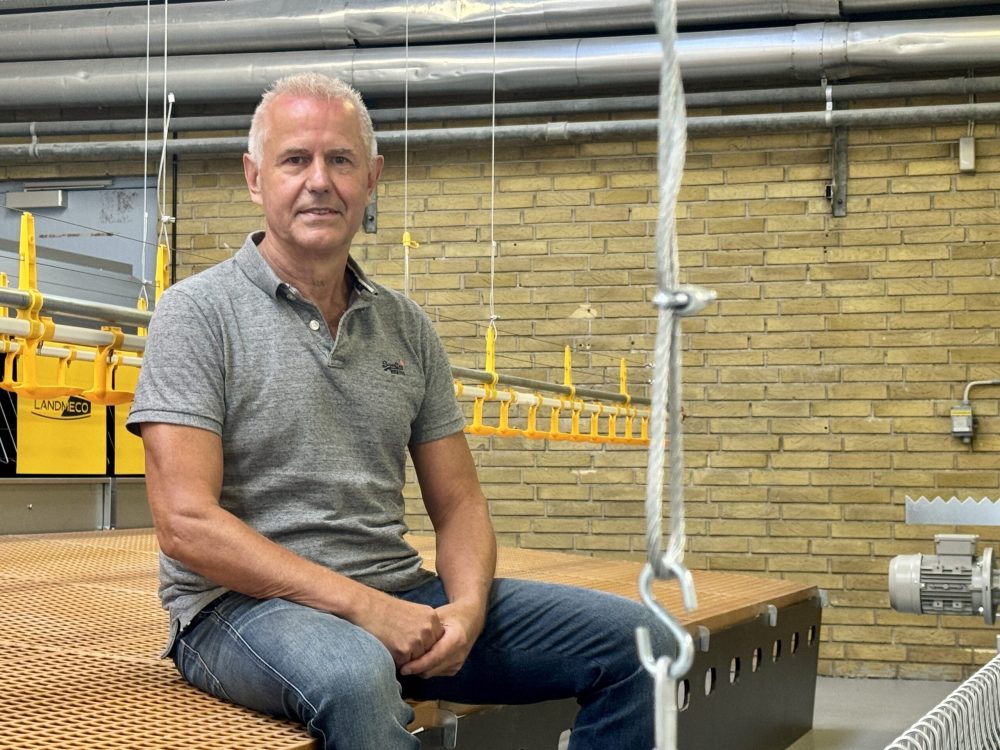 Ryan Zinglersen, International Dealer Manager at LANDMECO, sitting in a facility with poultry equipment.