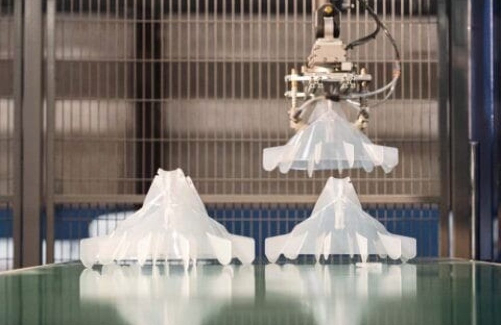 Sustainable Manufacturing of LANDMECO Poultry Systems Robotic arm assembling durable plastic components for LANDMECO poultry systems in a sustainable manufacturing facility.