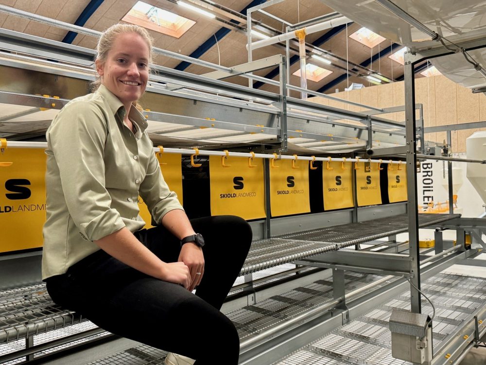 Angelika Jurgens Scaled sitting on a LANDMECO broiler system with yellow SKIOLDLANDMECO feeding equipment.