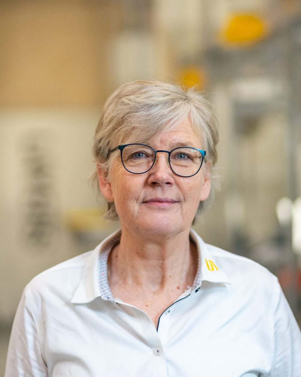 Portrait of Susanne Friis, LANDMECO Regional Sales Director, in a professional industrial poultry setting.