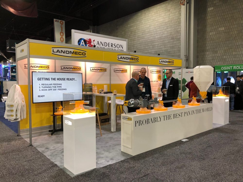 LANDMECO trade show booth featuring broiler feeding pans, Kick-off 330 system, and automated poultry equipment.