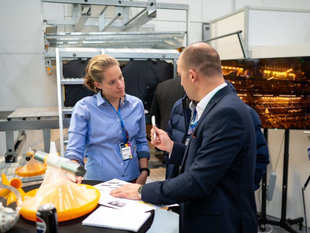 Angelika Jürgens of LANDMECO discusses poultry systems with a potential dealer at a trade fair.