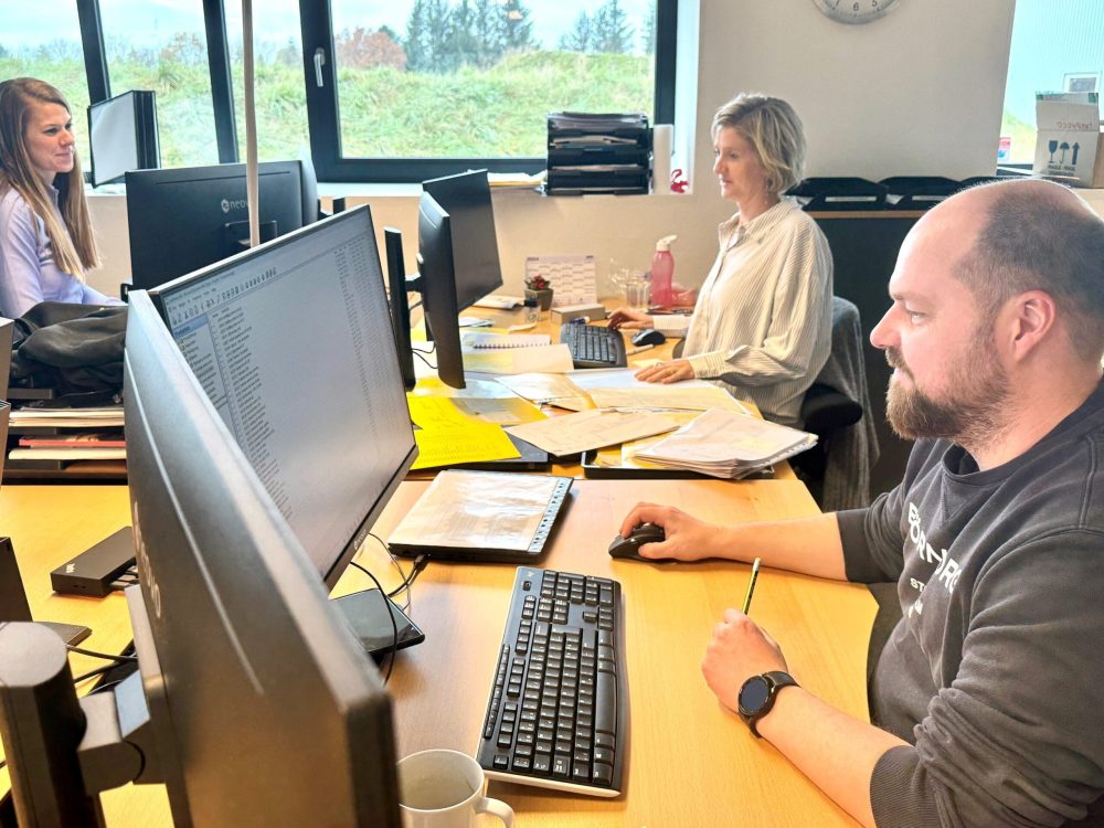 LANDMECO sales support team working at desks in the Ølgod office, managing poultry equipment orders and inquiries.