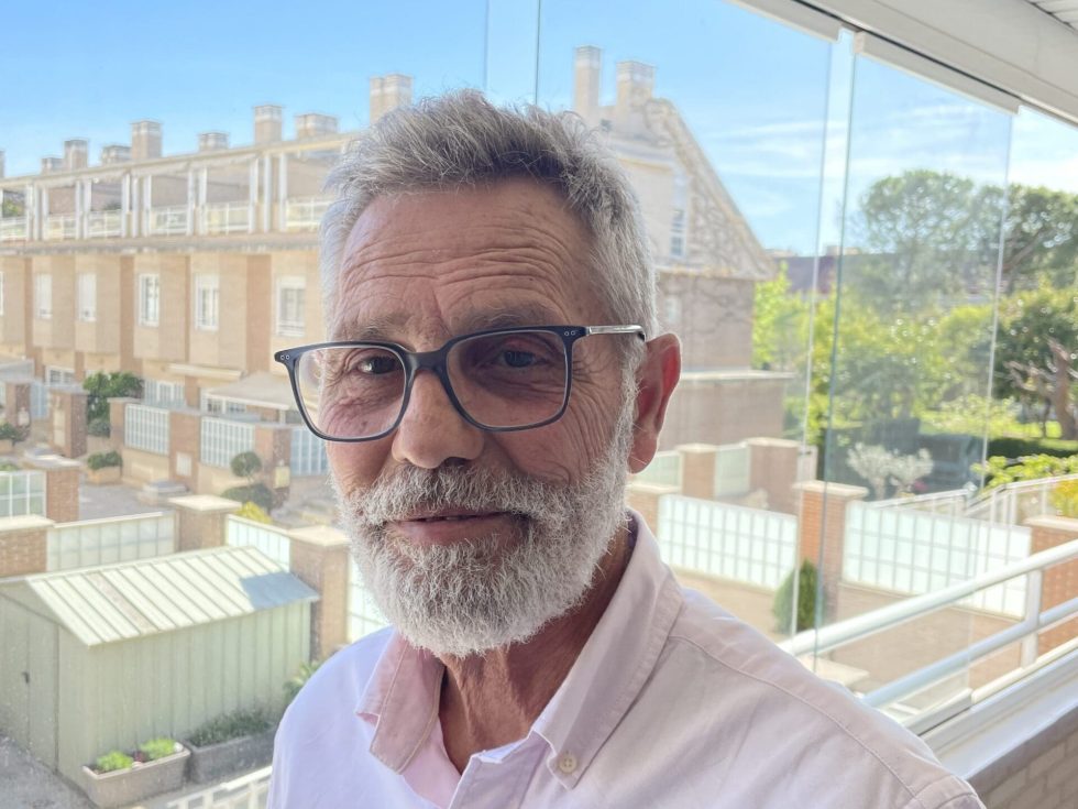 Marcelo Rotated, a seasoned poultry system professional, wearing glasses and a pink shirt on a balcony.