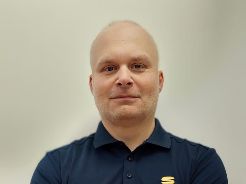 Marcin Wróblewski, poultry system specialist at LANDMECO, wearing a professional navy blue branded polo shirt.