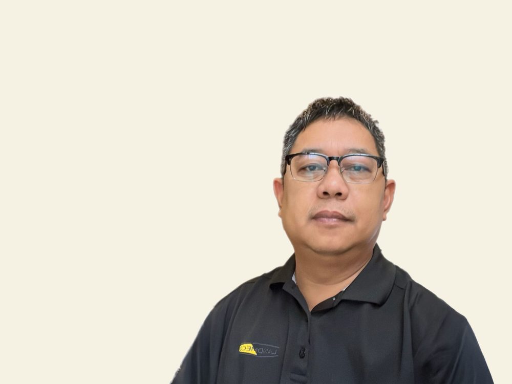 Roland Grabador Jr., LANDMECO Area Sales Manager for the Philippines, in a black branded polo shirt with glasses.