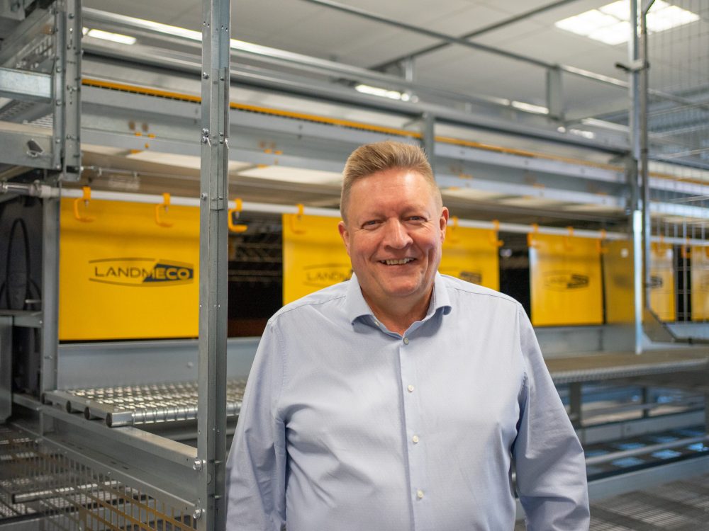 Tommy Høgedal Krogh, LANDMECO poultry specialist, standing in front of automated aviary systems.
