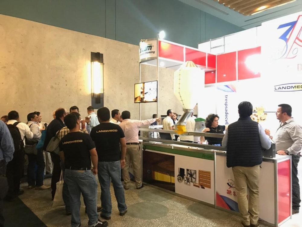 LANDMECO team presenting automated poultry farming equipment at a professional trade show exhibition booth.