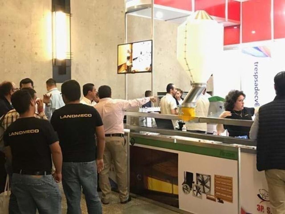 LANDMECO trade show booth featuring poultry farming equipment and systems with industry professionals.