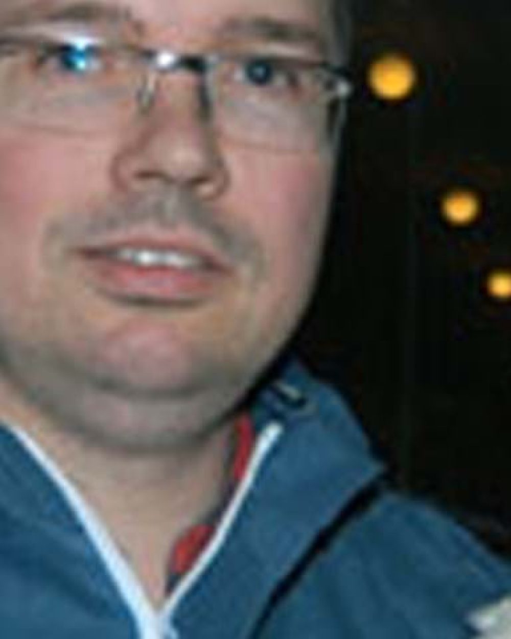 Landmeco Aasen holding a white hen, demonstrating poultry welfare in a professional farming environment.