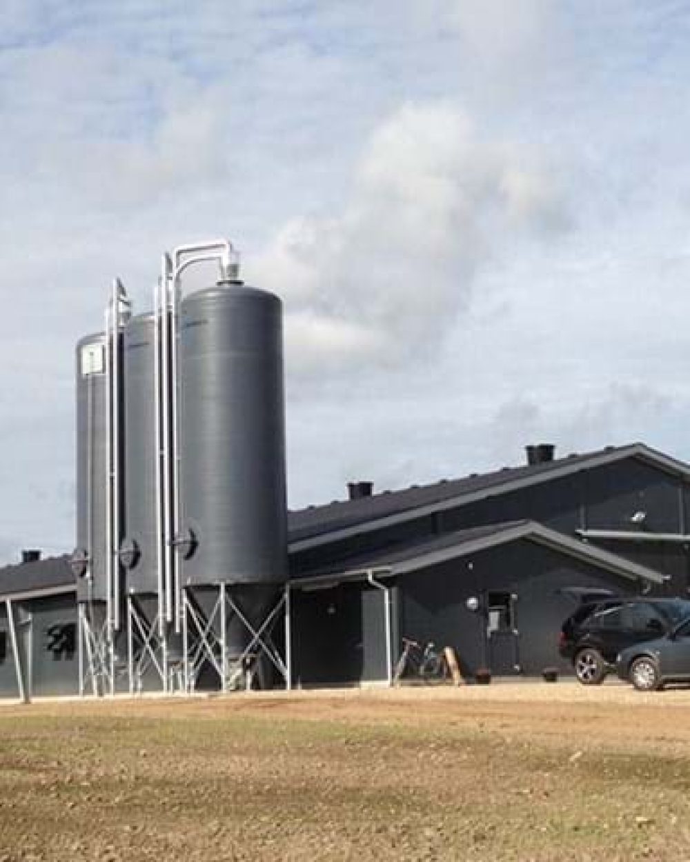 Modern poultry house with large feed silos and automated systems from LANDMECO, Denmark.