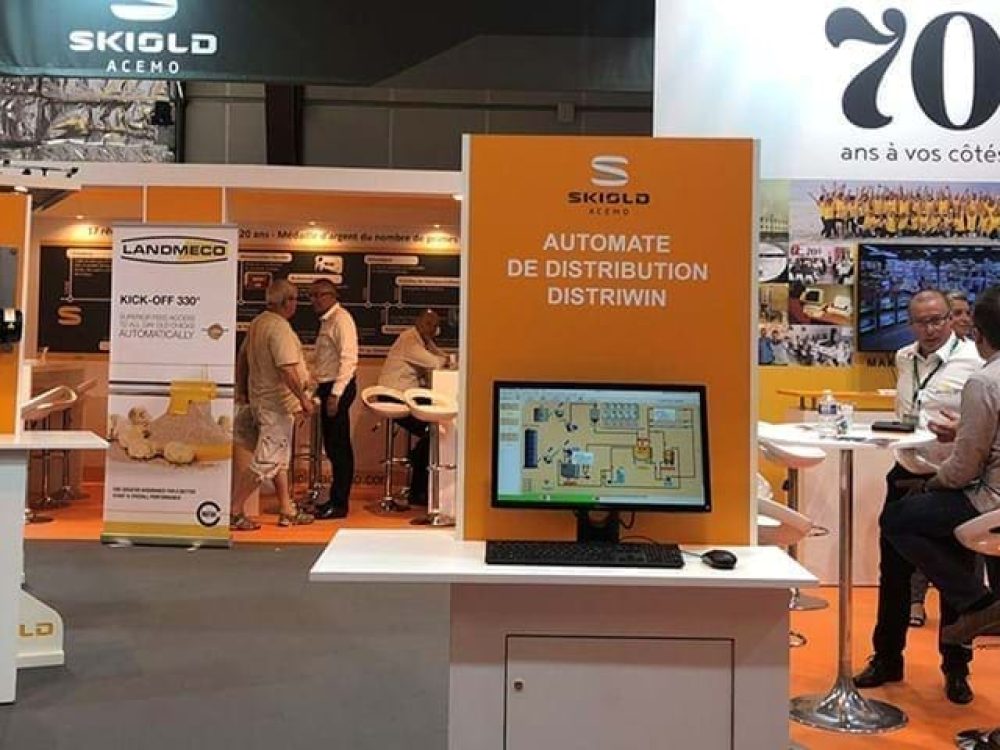 LANDMECO and SKIOLD exhibition booth featuring automated poultry feeding systems and distribution control software.