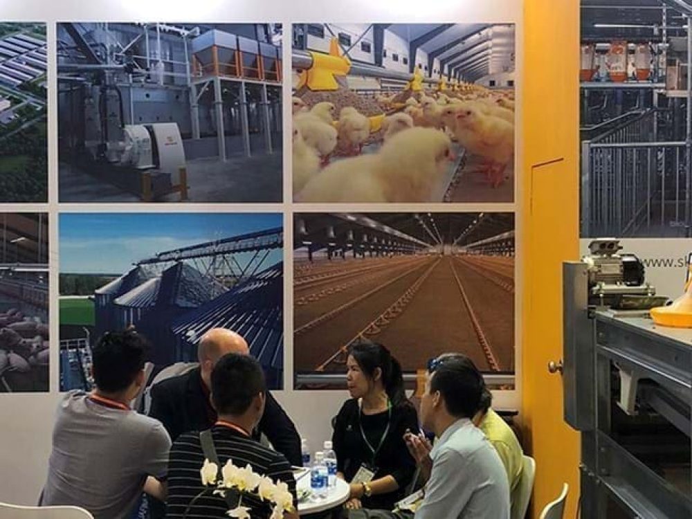LANDMECO Vietstock booth showing poultry farming equipment, chicks, silos, and B2B consultations at a trade show.