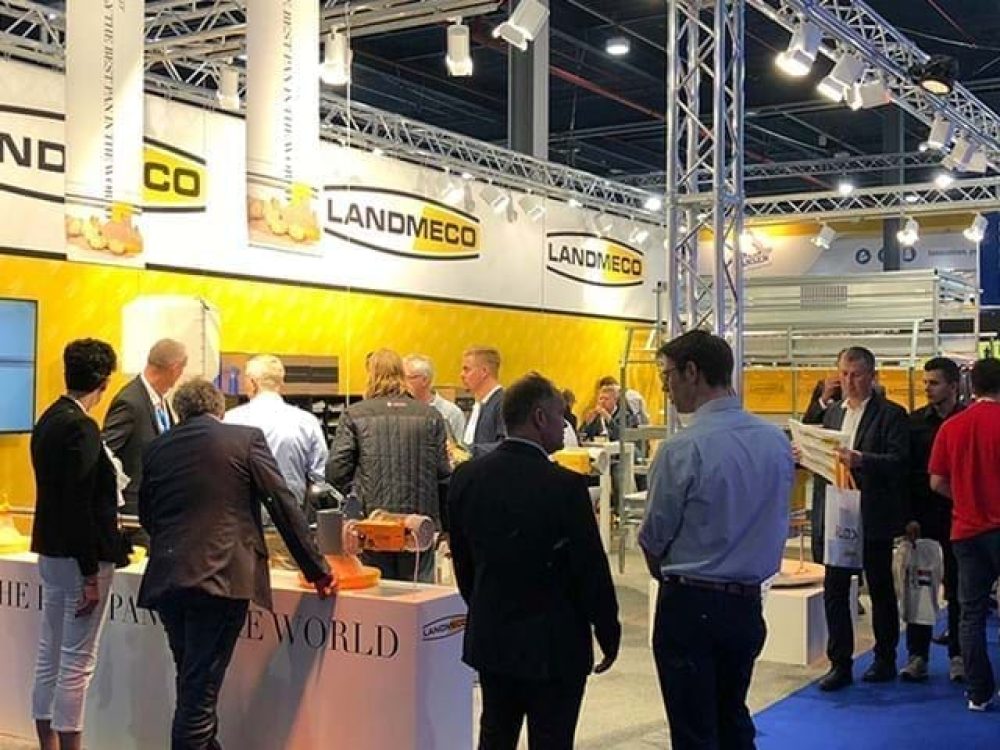 LANDMECO booth at VIV exhibition showcasing automated pan feeding systems and poultry house equipment to visitors.