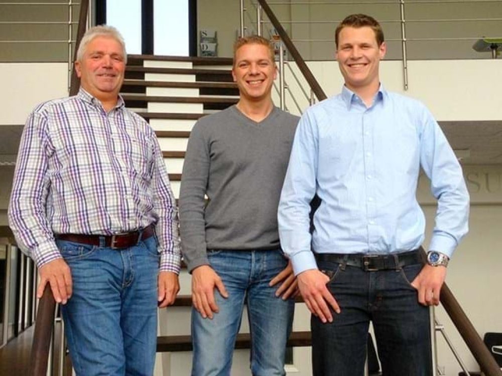 Three LANDMECO team members standing in a modern office, representing professional poultry equipment expertise.